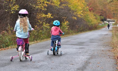 Girls riding on stabiliser bikes