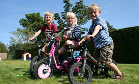 group of children on cycles, including a specialised trike for a disabled child.