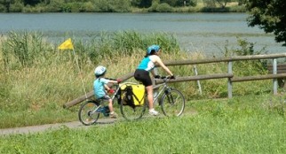 family cycling with a Tagalong bike - one wheel bike for child pulled behind an adult bike