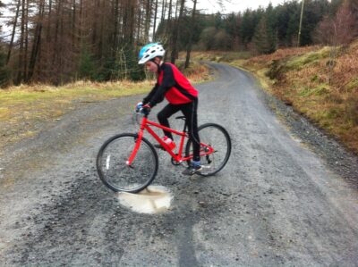 Best 26" kids' bikes: a boy riding an Islabikes Beinn bike on a gravel path