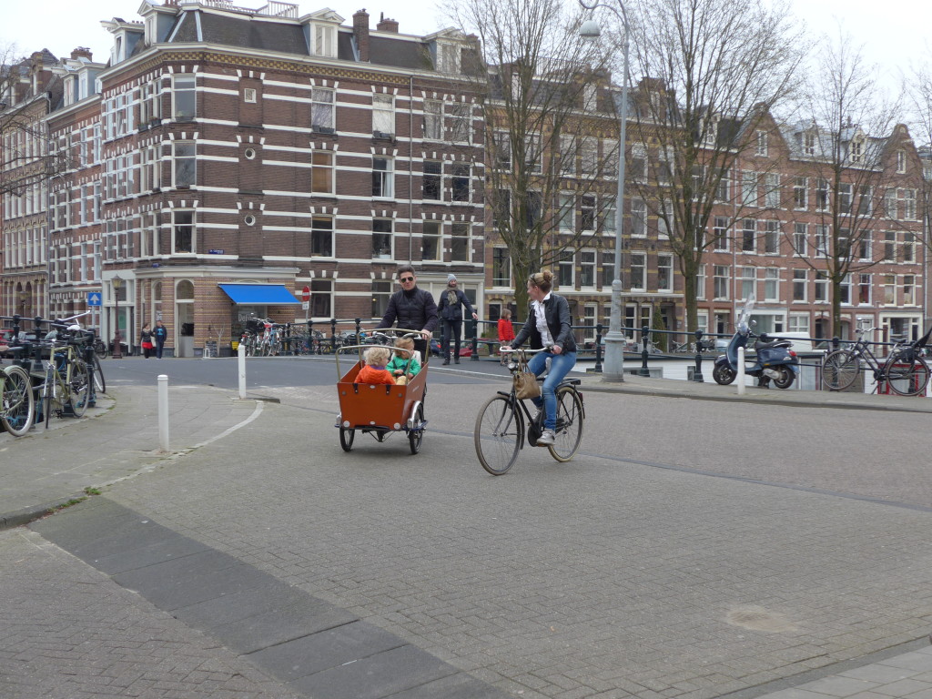 Photo of kids in cargo bike at a junction in Amsterdam