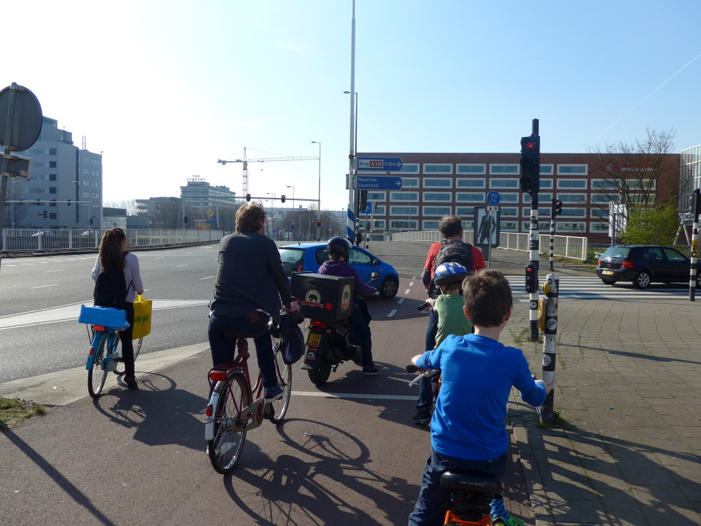 9 year old boy ycling on the segergated paths Amsterdam. If you're wanting to hire a kids bike in Amsterdam read this excellent guide to help you make the correct choice