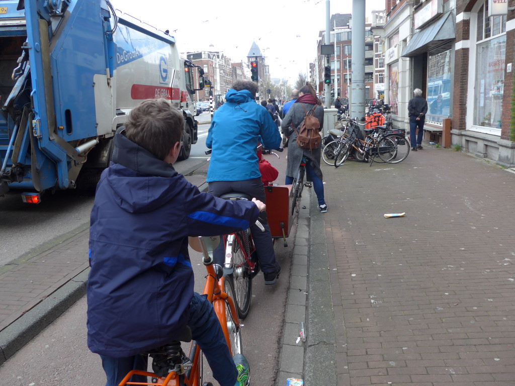 Cycling safely alongside a lorry in Amsterdam, Holland. If you hire a kids bike in Amsterdam it's easy to get around town to see all the sights