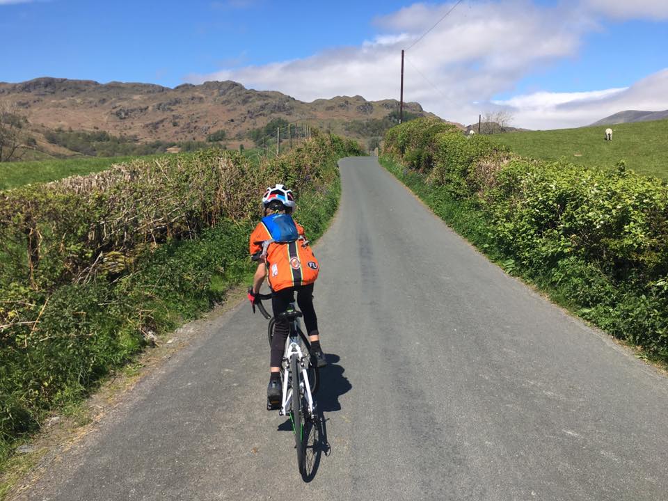 child cycling on country road in the summer