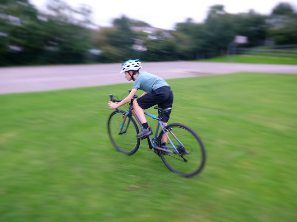 best bike for my child - Cuda CP700R kids road / cyclocross bike in action shot of cyclocross tyres on grass