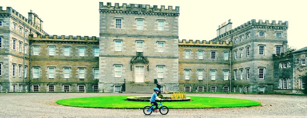 Young boy cycling in front of Mellerstain House