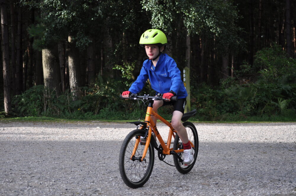 best bike for my child - boy on orange Frog 55 hybrid bike