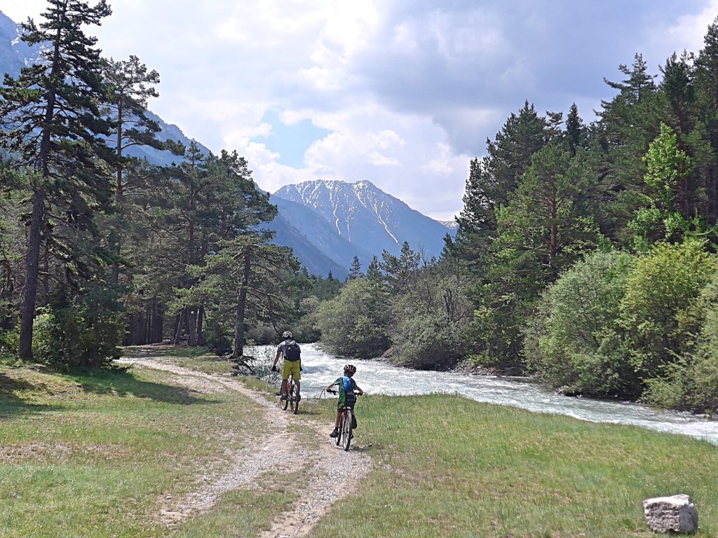 Family cycling in the Vallée de la Clarée in the French Alps - trail by the river Clarée