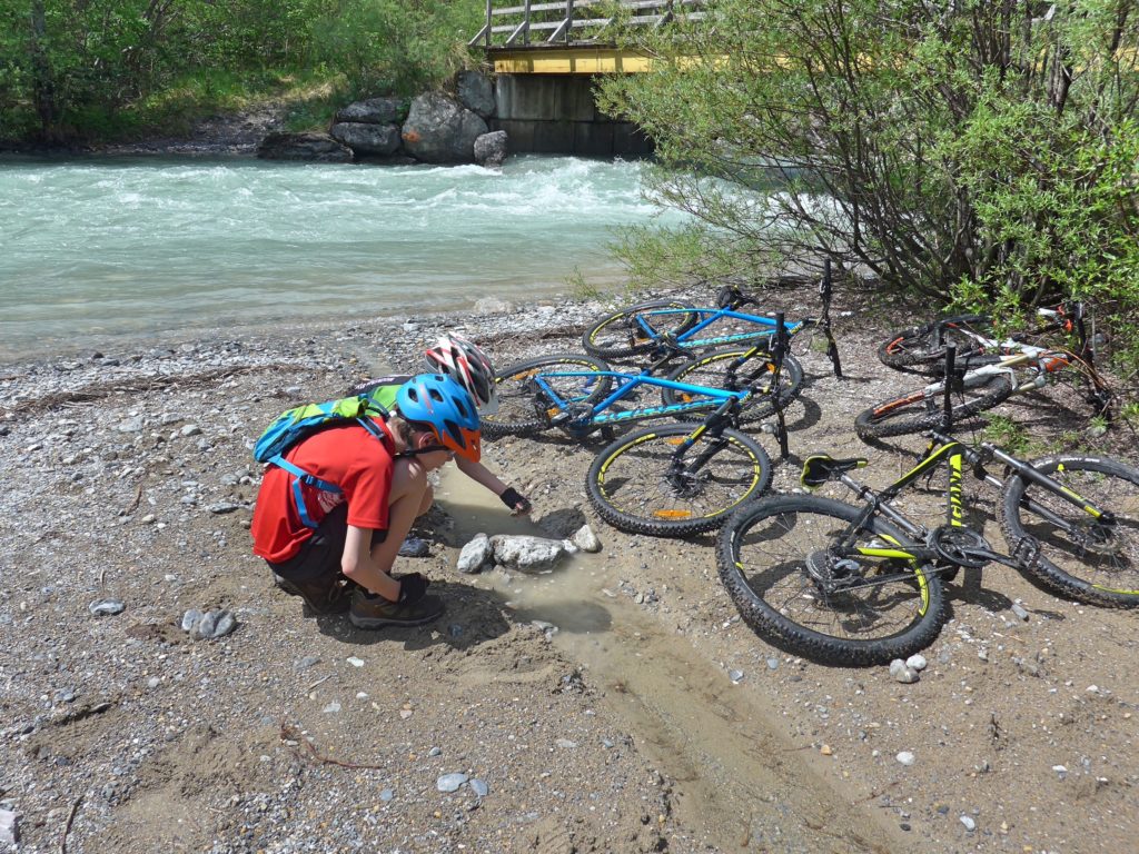 Family cycling in the Vallée de la Clarée in the French Alps - perfect place for the children to do a bit of dam building