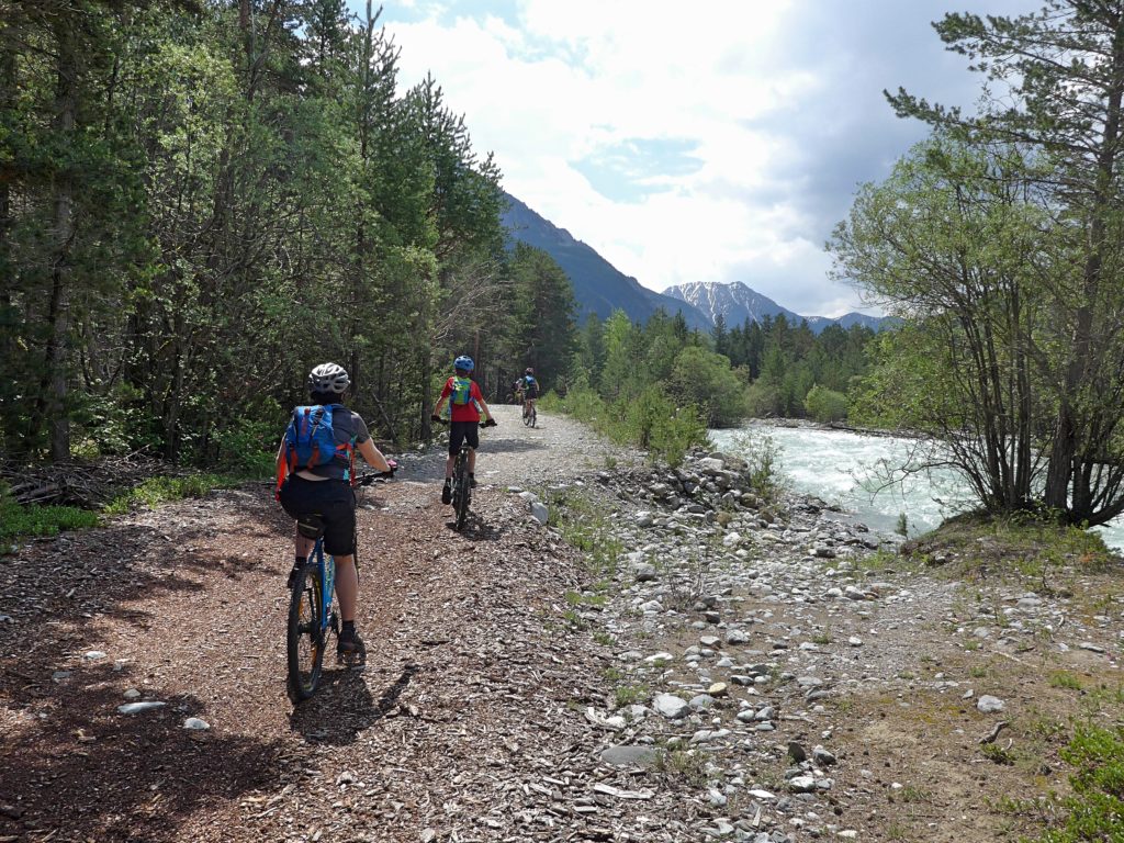 Family cycling in the Vallée de la Clarée in the French Alps - bikes following the river Clarée