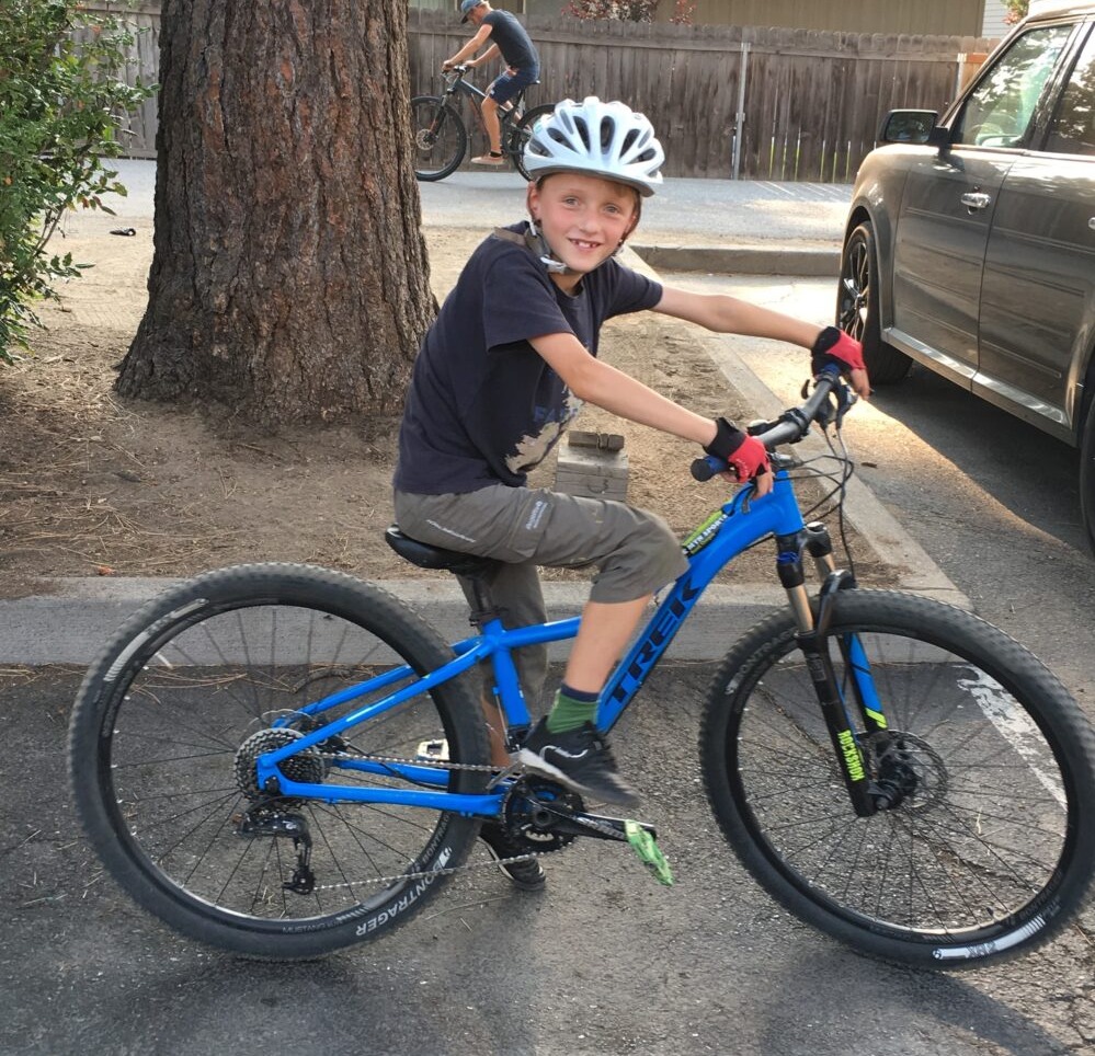 How to choose the right size kids' bike: A boy posing on a mountain bike, looking at the camera