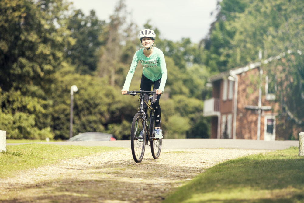 How to choose the right size kids' bike: A teenage girl cycling towards the camera