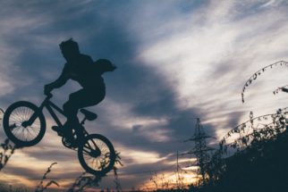 Photo of child cycling without a cycle helmet = Photo by Julia Komarova on Unsplash