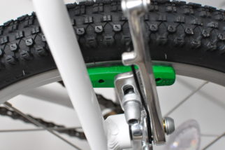 Green brake blocks on the Woom 3 16" wheel kids bike