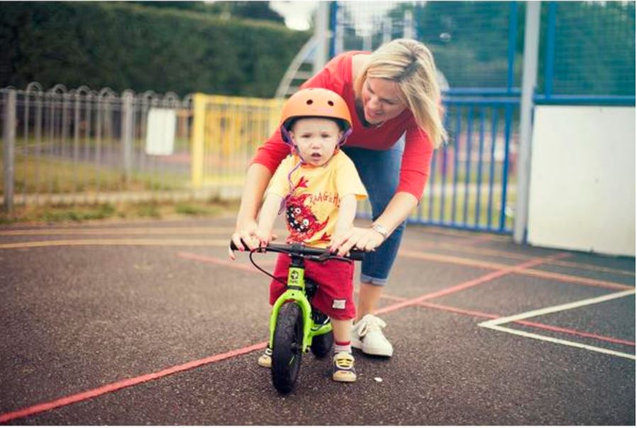 How to choose the right size kids' bike: A mum helping her toddler ride a Frog Tadpole