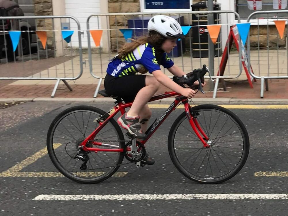 Best 26" kids' bikes: A girl riding an Islabikes Luath road bike in a race