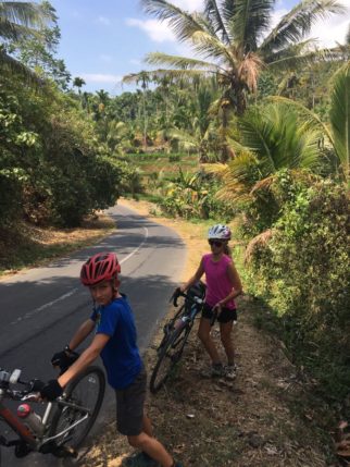 Pushing bikes up the hill in Sembalum Valley, Lombok, Indonesia