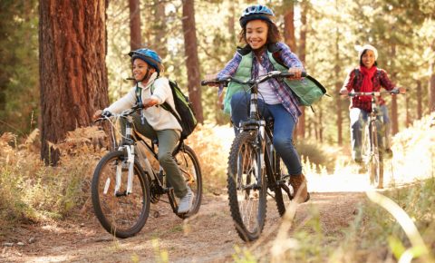 Two kids riding mountain bikes with an adult