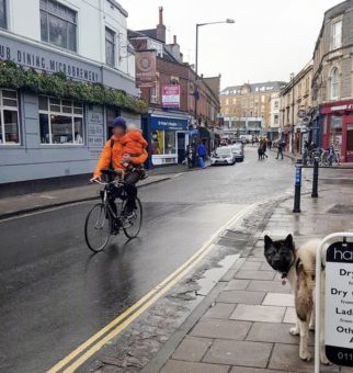 Man on bike holding child in Bristol