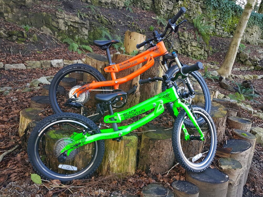 Best kids' bikes: Two Black Mountain bikes leaning against some logs