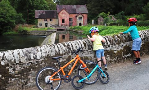 Islabikes kids looking over wall at Mill