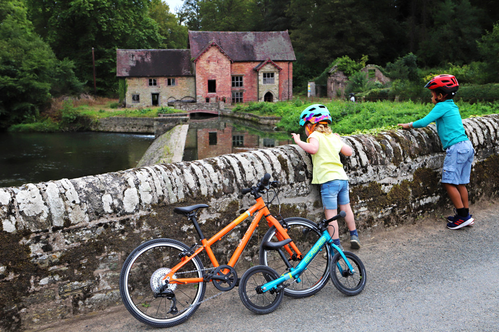 Islabikes kids looking over wall at Mill