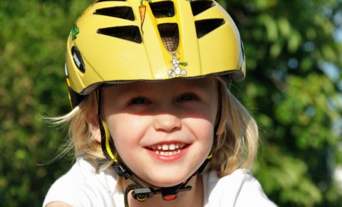 Smiling young girl in yellow cycle helmet?