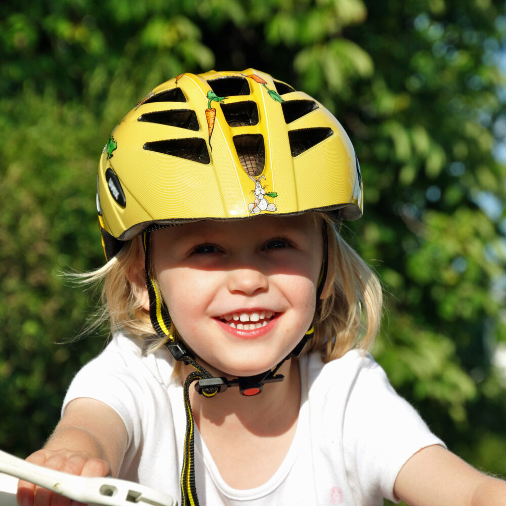 Smiling young girl in yellow cycle helmet?