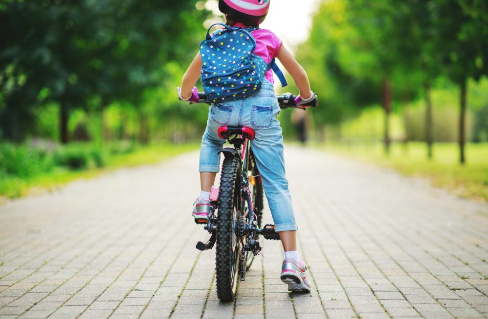 child sitting on bike with rucksack on