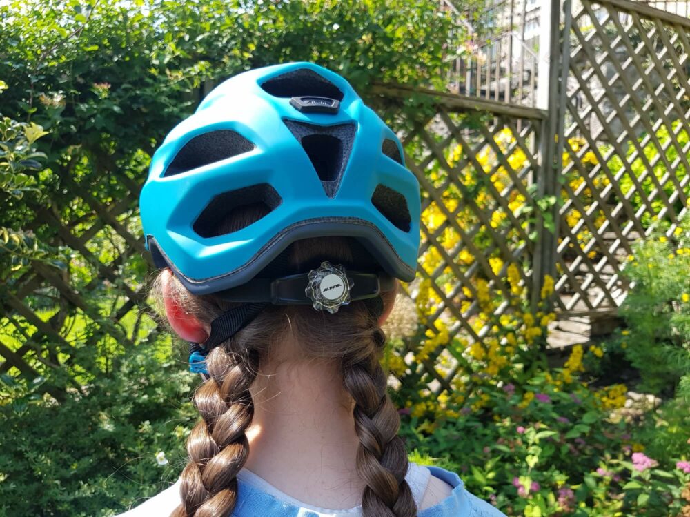 Alpina Carapax Jr. kids helmet shown with plaits