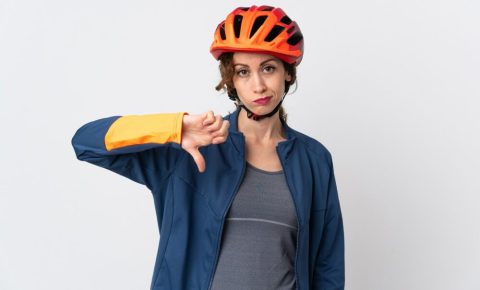 Woman in cycle helmet with thumbs down