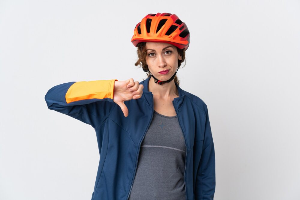 Woman in cycle helmet with thumbs down