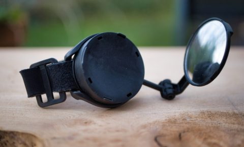 Myklops Bike Mirror Review- photo of the Myklops in the open position, resting on a wooden surface