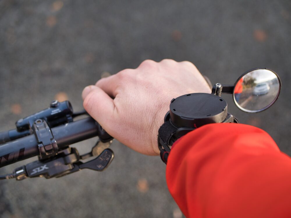 Closeup photo of the review Myklops biycle mirror being used whilst riding a flat handlebar bike