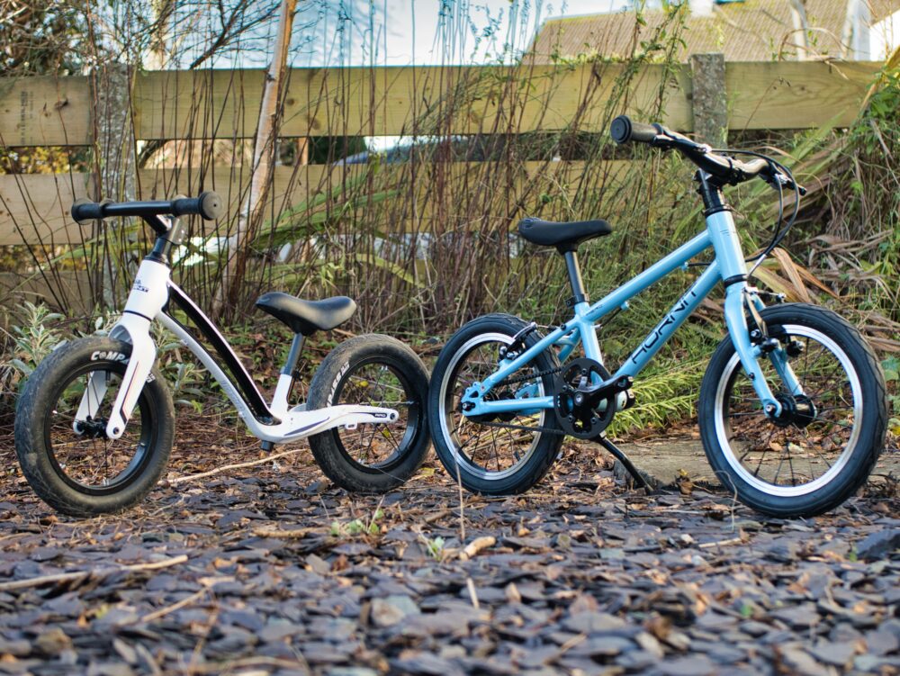 Photo of the Hornit AIRO balance bike next to he Hornit HERO 14 kids bike with the pedals taken off to turn it into a larger balance bike