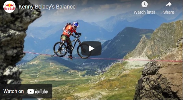 Kenny Belaey Balance film - photo of him riding a bike on a slack wire across an alpine valley