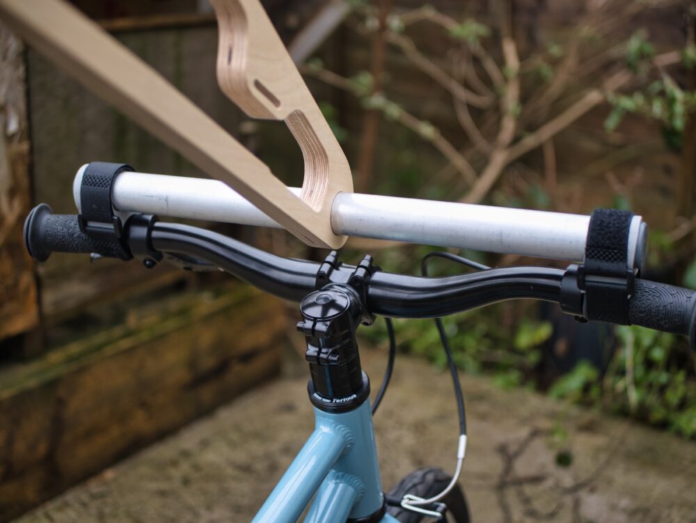 The wheelie bike handle attached to a 14" wheel kids bike ready to be used for pushing the child's bike back from school