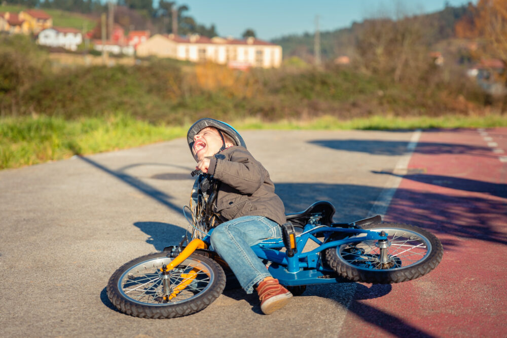 Boy falling off pedal bike when trying to ride, once stabilisers have been removed