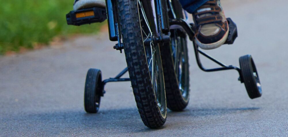 Close up of stabilisers in use, showing how the bike turns into a tricycle when you fit training wheels and causes problems 