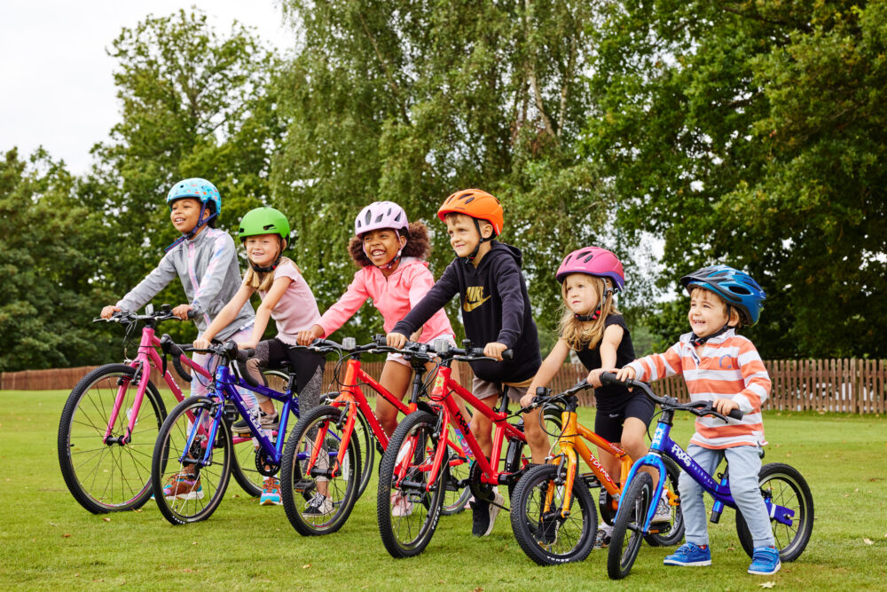 Group photo of six children of different ages on Bike Club bikes ranging from balance bike through to larger 26" wheel bike. All available to lease or rent on a long term susbscription