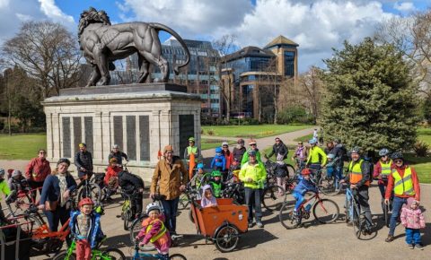 Kidical Mass in Reading UK - riders gather at the start of the ride with their bikes in front of a statue