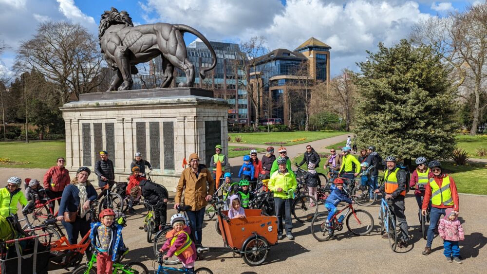 Kidical Mass in Reading UK - riders gather at the start of the ride with their bikes in front of a statue