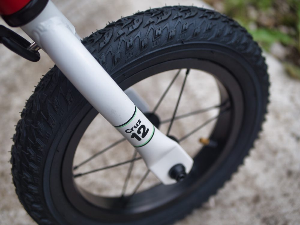 White fork and black wheel on the Hoozar Cruz 12 balance bike - the word Cruz 12 is on the fork where it meets the wheel