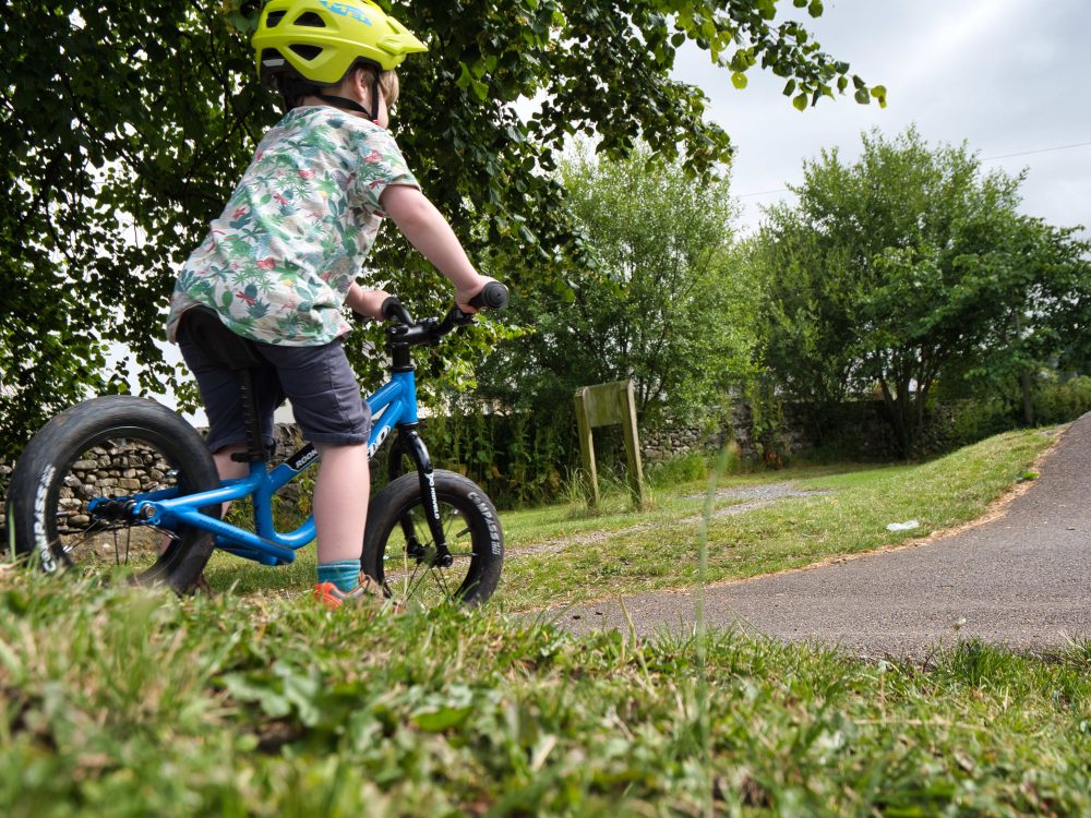 Best kids' bikes: A small child riding a balance bike in the park