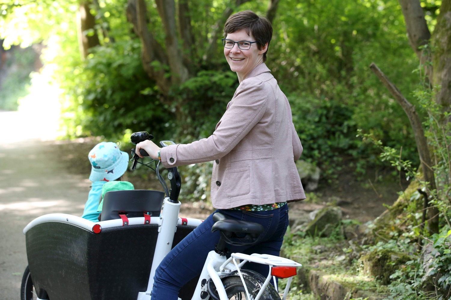Saskia Heijltjes on a cargo bike with two children in the box at the front