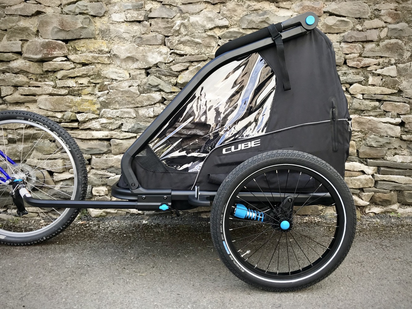 Side view of the Cube CMPT double trailer attached to rear of adult bike for towing