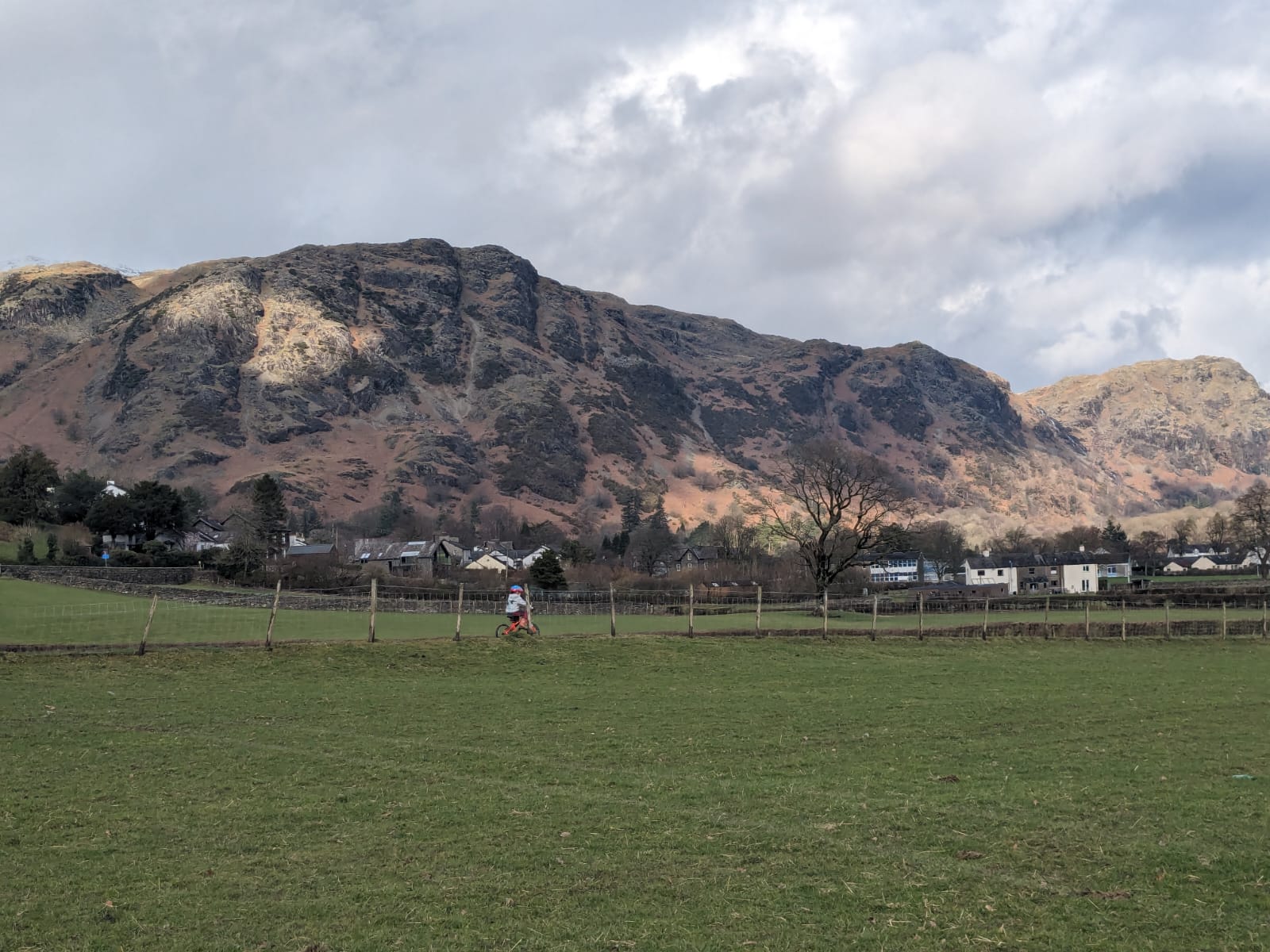 coniston mountains in the background of a child riding his bike