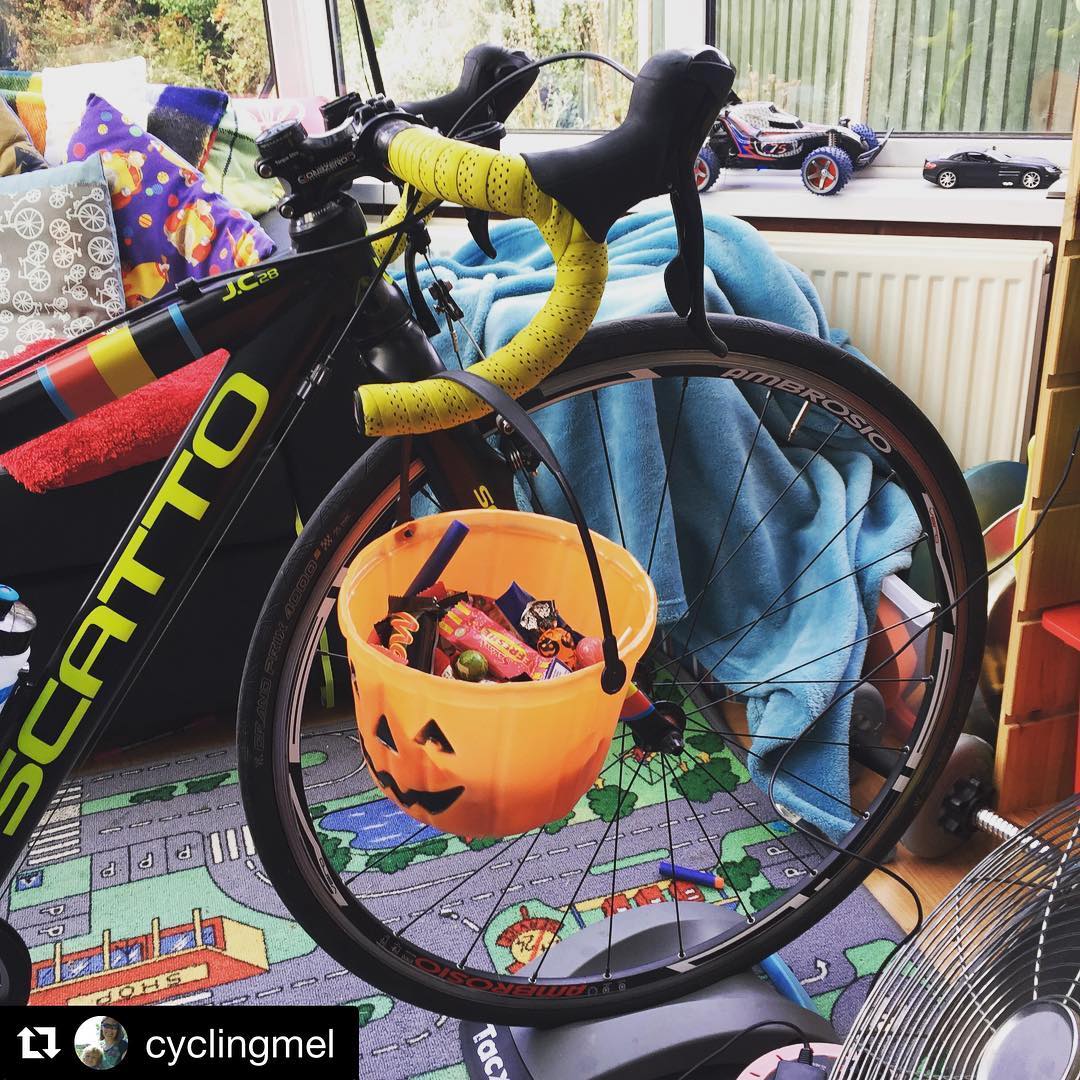 Halloween Costumes for Cycling Kids: The front end of an adult's road bike with a pumpkin bucket dangling from the drop handlebar