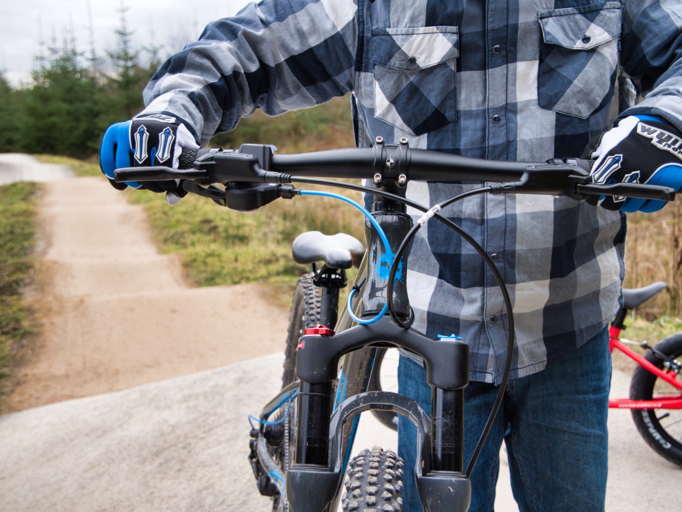 Boy in a checked shirt pushing the Frog 62 MTB