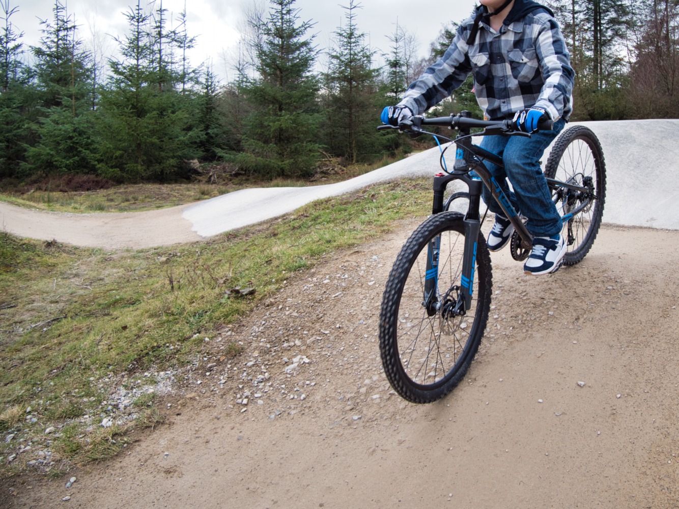 Boy riding a Frog 62 Mountain Bike on a pump track